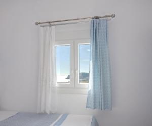 a bedroom with a window with a view of the ocean at Sarantis apartments in Provatas