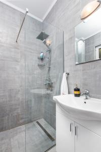 a bathroom with a white sink and a shower at Apartments Stetonn in Kotor