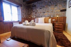 1 dormitorio con 1 cama grande y toallas. en Hotel Rural El Molino, en Soto de Cangas 37 fotos más