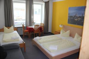 een hotelkamer met 2 bedden en een tafel bij Hotel Pension am Hauptbahnhof in München