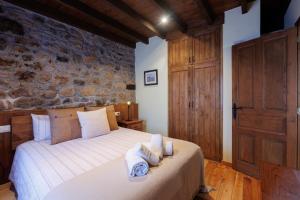 a bedroom with a bed with towels on it at Hotel Rural El Molino in Soto de Cangas