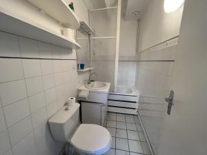 une salle de bains blanche avec toilettes et lavabo dans l'établissement Cottage de la mer, au Crotoy 16 autres photos