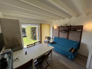 un salon avec un canapé bleu et une fenêtre dans l'établissement Cottage de la mer, au Crotoy