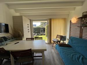 un salon avec une table et un canapé bleu dans l'établissement Cottage de la mer, au Crotoy