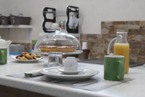 a kitchen counter with a plate of food and orange juice at AG sweet apartment in Reggio di Calabria