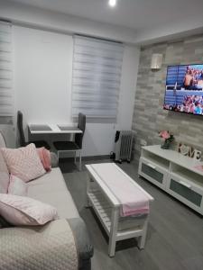 sala de estar con sofá y TV en La Casita de Ubrique, en Ubrique