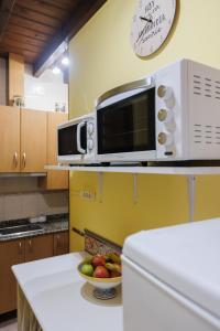 a kitchen with a microwave and a bowl of fruit on a counter at Hotel Rural El Molino in Soto de Cangas