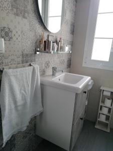 a white bathroom with a sink and a mirror at La Casita de Ubrique in Ubrique