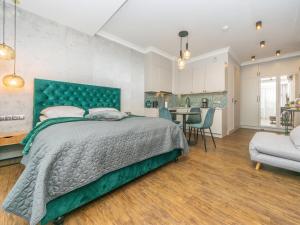 a bedroom with a large bed and a kitchen at Flatbook - City Center Apartments Granaria II in Gdańsk