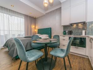 a kitchen with a table and chairs in a room at Flatbook - City Center Apartments Granaria II in Gdańsk