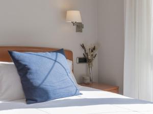 un cuscino blu seduto sopra un letto di Hostal ALBA Lugo a Lugo