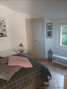 a bedroom with a bed with a pink pillow and a tub at UNE CHAMBRE EN VILLE in L'Isle-sur-la-Sorgue