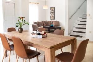 a dining room with a wooden table and chairs at Naelia in Pastida
