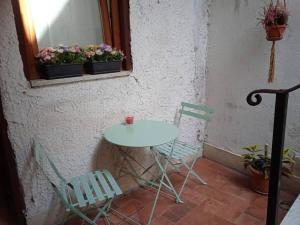 een tafel en twee stoelen en een tafel met bloemen bij Appartamentino in Piazza in Trevignano Romano
