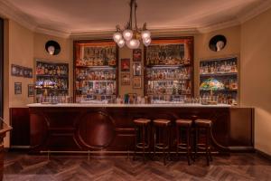 un bar con taburetes y estanterías de alcohol en Hotel Locarno en Roma