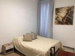 1 dormitorio con 1 cama y una pintura en la pared en Appartamentino in Piazza en Trevignano Romano