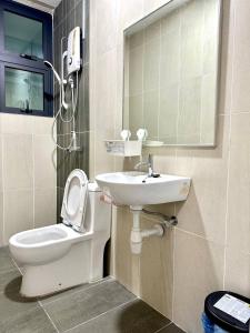 y baño con aseo y lavamanos. en KLCC Kampung Baru Cottage - Homestay en Kuala Lumpur