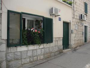 a window with green shutters on a building with flowers at Studio Toniko in Split