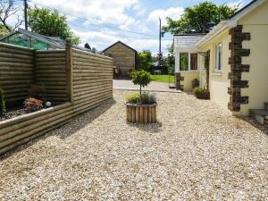 a gravel driveway with a fence and a garden at Little Coombe in Ashbury