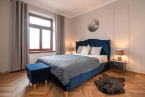 a bedroom with a blue bed and a mirror at Apartament Kolegialna 8 in Płock