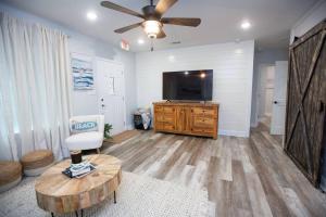a living room with a flat screen tv and a table at Captain's Cove in Long Beach