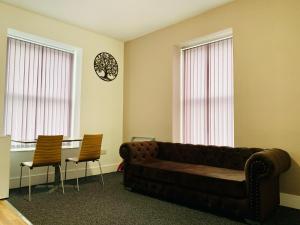 a living room with a couch and two chairs at Marina Apartments in Bradford