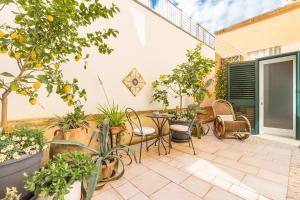 eine Terrasse mit einem Tisch, Stühlen und Bäumen in der Unterkunft Dimora Le Tre Muse Guesthouse in Lecce