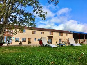 a group of chairs sitting in the grass in front of a building at Domaine Joseph LAFARGE Wine Resort B&B in Lugny