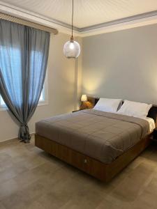 um quarto com uma cama grande e uma cortina azul em Olive Hill Apartment em Karpofóra
