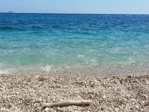 a log laying on a beach near the water at B&B Antico Telaio in Santa Maria Navarrese