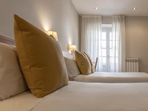 卢戈Hostal ALBA Lugo的卧室里有一张白色的床，配有枕头和一扇窗户