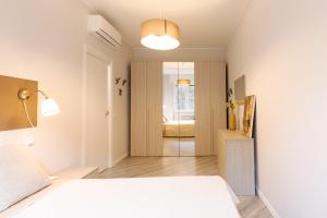 1 dormitorio con cama blanca y 1 habitación con sofá en NEW! Milano - Flowers Home, en Cusano Milanino