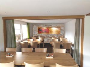un restaurant avec des tables et des chaises et un mur en pierre dans l'établissement Gasthaus Hirschen AG, Oberiberg, à Oberiberg