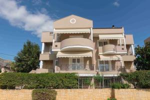 um edifício alto com uma cerca em frente em Helios: Charming beach home next to crystal waters em Nea Makri