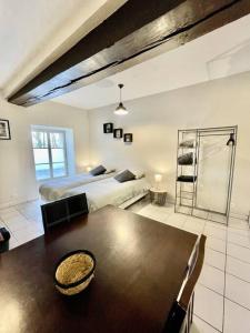 ein Wohnzimmer mit 2 Betten und einem Tisch in einem Zimmer in der Unterkunft *Au centre de la ville haute G* ZEN LOC 6 in Provins