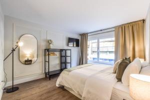 una camera con un grande letto e una grande finestra di AmazINN Places Gran Via VII a Madrid