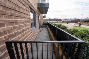 a balcony of a building with a window at Newly Built Spacious Apartment easily accessible to Luton Airport, Town centre and station in Luton