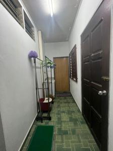 a hallway with a room with a door and a plant at HOMESTAY NO.45 in Jitra