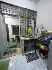 een kamer met een keuken met een wastafel bij HOMESTAY NO.45 in Jitra