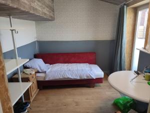1 dormitorio con 1 cama con cabecero rojo en Ferienhof-Störwiese, en Arpsdorf