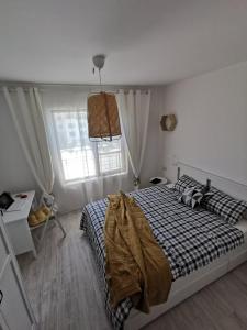 a bedroom with a bed with a black and white comforter at Lily Beach - Apartment 408A in Sozopol