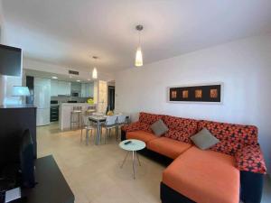 salon z czerwoną kanapą i kuchnią w obiekcie Impresionante piso de planta baja cerca al mar w mieście Torrevieja
