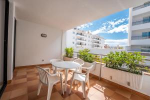 balcón con mesa blanca y sillas en Beatrix 2000 - Caliu apartments, en Pineda de Mar