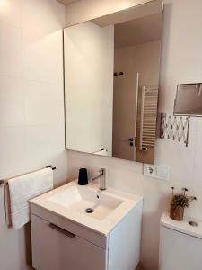 La salle de bains blanche est pourvue d'un lavabo et d'un miroir. dans l'établissement #PrettyPenthouseEstepona, à Estepona