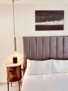 un lit avec une tête de lit en cuir et une table de chevet à côté d'un lit avec dans l'établissement #PrettyPenthouseEstepona, à Estepona