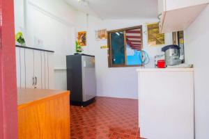 uma cozinha com um frigorífico e piso em azulejo vermelho em FREDA poolvilla em Ban Khlot