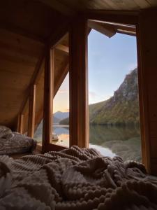 a bedroom with a bed with a view of a lake at Floating House Perućac in Perućac