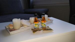 a table with two bottles of beer and candles on it at FeWo Eggers 1 in Burgtiefe auf Fehmarn 