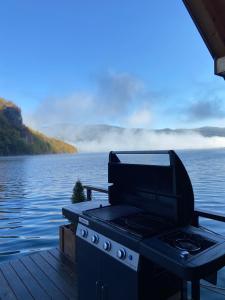 a grill on a dock next to a body of water at Floating House Perućac in Perućac