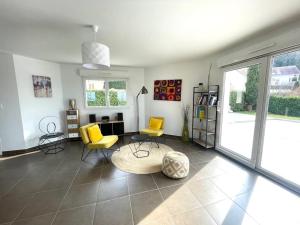 ein Wohnzimmer mit gelben Stühlen und einem Tisch in der Unterkunft Superbe maison Châtillon-Le-Duc 